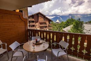 einen Tisch und Stühle auf einem Balkon mit Aussicht in der Unterkunft Morillon 1100 Skis aux pieds in Morillon