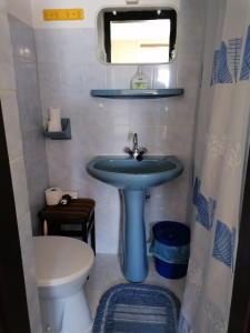 a bathroom with a blue sink and a toilet at Ildikó Vendégház Hévíz in Hévíz