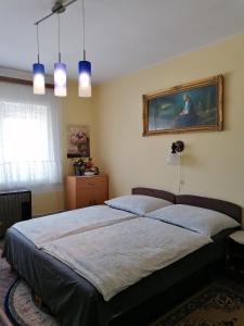 a bedroom with a bed and a painting on the wall at Ildikó Vendégház Hévíz in Hévíz