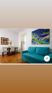 sala de estar con sofá azul y mesa en Felipe de Oliveira Apartment, en Río de Janeiro