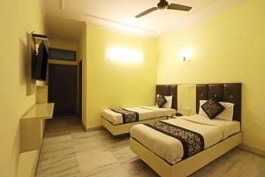 Habitación de hotel con 2 camas y TV de pantalla plana. en Silver Shine New Delhi - COMFORT STAY, en Nueva Delhi