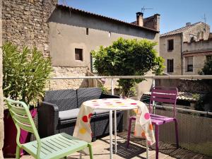 a patio with chairs and a table on a balcony at Chez Waucquier in Beaucaire