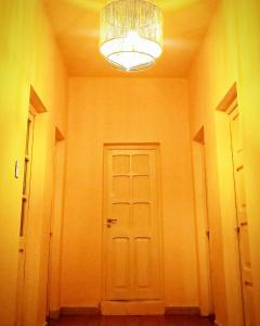 a hallway with a white door and a chandelier at Hostel LQueen 1 in Salta