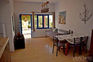 a dining room with a table and a table and chairs at Vrachos Apartments in Frangokastello