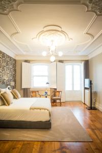 a bedroom with a large bed and a chandelier at Conquistador Palace in Guimarães