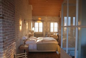 アル・アン・レにあるHôtel Le Sénéchalのレンガの壁、ベッド付きのベッドルーム1室