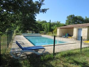 a fence with a swimming pool in a yard at Gite un toit sur la Doa in Apt