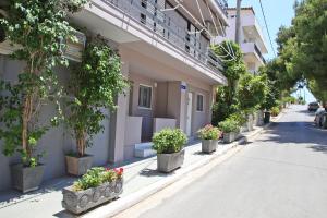 a row of potted plants on the side of a building at Comfortable apartment near Athens Airport!! in Spáta