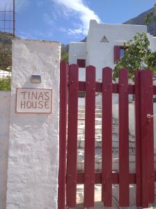 a red fence with a sign that reads times house at TINA'S HOUSE OUTSTANDING SEASIDE HOUSE Kamares Sifnos in Kamares