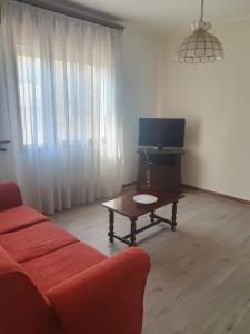 a living room with a couch and a table and a tv at Margi House in Bigolino