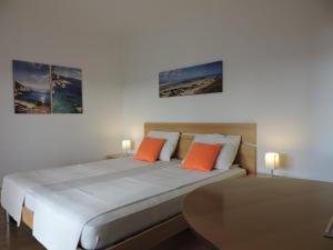 a bedroom with a bed with orange pillows and a table at Villa Bianca in Trogir