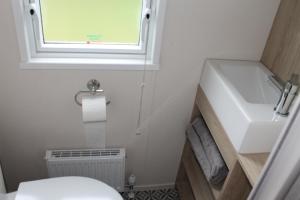 a small bathroom with a sink and a toilet at luxury new 3 bed caravan with stunning sea view on private beach in Thorness bay in Porchfield