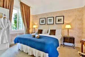 ein Schlafzimmer mit einem großen Bett mit einer blauen Decke in der Unterkunft Château de Villars in Villars