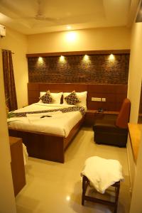 a hotel room with a bed and a chair at Horizon Inn in Chennai