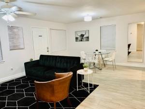 a living room with a black couch and a table at Mayfield @ Oyster Creek - Tranquil Creek & Nature! in Sugar Land