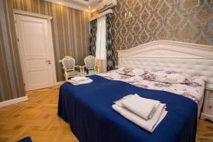 a bedroom with a blue bed with towels on it at Sanata in Tbilisi City