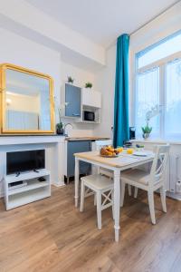 - une cuisine avec une table, des chaises et un miroir dans l'établissement Lovely Bail - Studio au calme - WIFI, à Douai