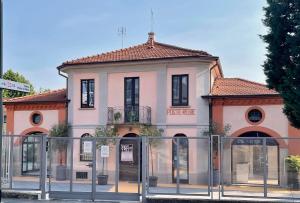 un edificio rosa con un cancello di fronte di Poste Regie - Milan Guest House a Milano