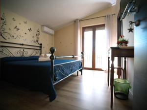 ein Schlafzimmer mit einem blauen Bett und einem Fenster in der Unterkunft Villa Anté in Angri