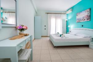 two beds in a room with blue walls at Malandris Studios in Skala Marion