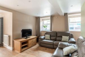 a living room with a couch and a flat screen tv at Milo's place is a home from home in Egremont