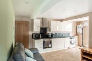 a living room with a couch and a kitchen at Milo's place is a home from home in Egremont