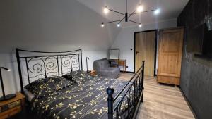 - une chambre avec un lit noir et une chaise dans l'établissement Willa Pod Reglami, à Zakopane 4 autres photos
