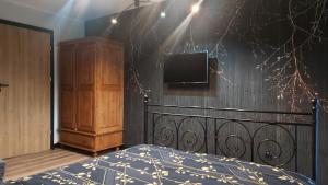 - une chambre avec un lit et une télévision murale dans l'établissement Willa Pod Reglami, à Zakopane