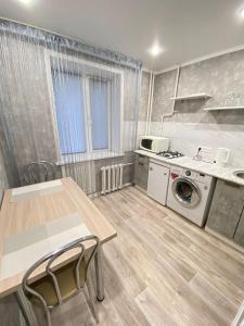 a kitchen with a table and a washing machine at Vip квартира Центр in Uralsk