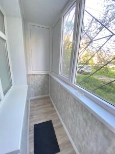 um quarto com duas janelas e um tapete em Vip квартира Центр em Oral