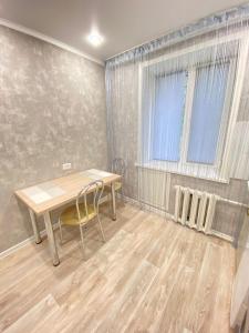 a dining room with a table and a window at Vip квартира Центр in Uralsk