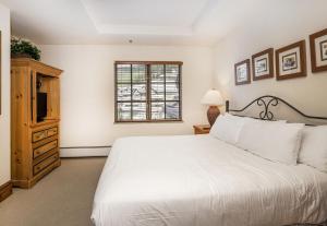 um quarto com uma cama branca e uma janela em Market Square 306 condo em Beaver Creek