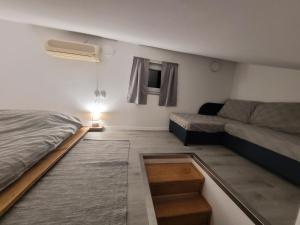 Habitación pequeña con cama y sofá en Apartment Daniel, en Novalja