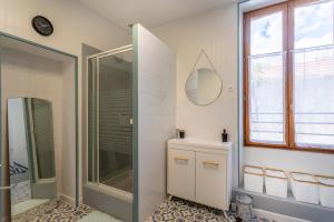 uma casa de banho com um chuveiro e um espelho. em Monesto Gite maison de ville cité médiévale em Mennetou-sur-Cher
