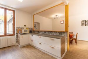 a kitchen with white cabinets and a microwave at Monesto Gite maison de ville cité médiévale in Mennetou-sur-Cher