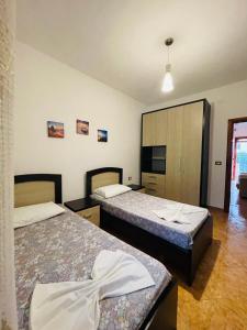 a hotel room with two beds and a tv at Baka Guest House in Durrës