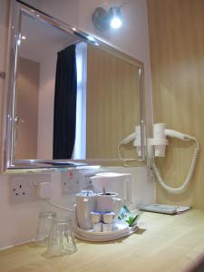 a bathroom counter with a mirror and a sink at Alhambra Hotel in London +66 photos