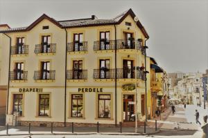 - un bâtiment jaune avec des fenêtres et des balcons dans une rue dans l'établissement CENTRAL VIEW Craiova, à Craiova