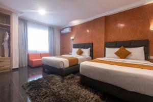 una camera d'albergo con due letti e una sedia di Airport View Hotel a Accra