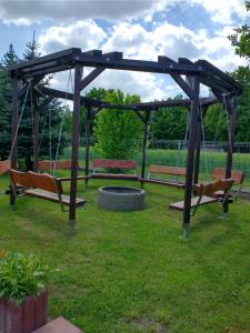 a group of benches sitting under a gazebo at Całoroczne Leniuchowo in Ponizie