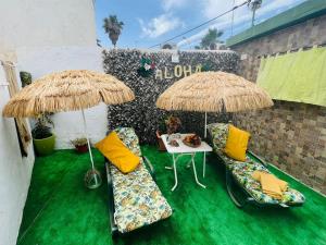 a patio with two chairs and two umbrellas at Beach house MAREA CORAL in Melilla