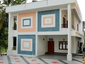 a house with blue and orange paint on it at Wanderlust Residence Homestay in Thekkady