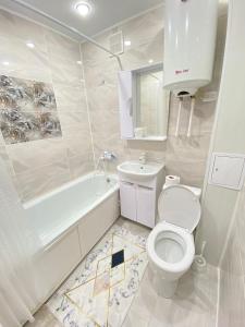 uma casa de banho com um WC, uma banheira e um lavatório. em Vip квартира Центр em Oral