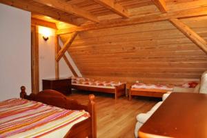 a room with two beds in a wooden house at Całoroczny dom w Powałczynie w spokojnej okolicy. in Powałczyn