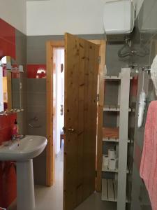a bathroom with a sink and a wooden door at Appart Chris Mindelo in Mindelo +58 photos