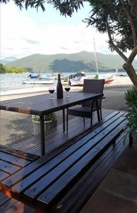 a picnic table with a vase and two glasses of wine at Holiday Home By The Sea--Bougainvillea in Ston