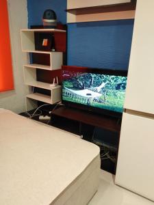 sypialnia z łóżkiem, telewizorem i biurkiem w obiekcie Viršu street apartaments 5 w mieście Lipawa
