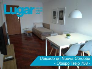 Departamentos Lugar في قرطبة: غرفة معيشة مع طاولة وكراسي بيضاء