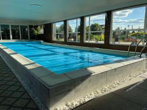 duży basen z niebieską wodą w budynku w obiekcie Villa Grand Family w mieście Rozhny