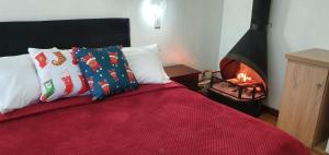 1 dormitorio con 1 cama y chimenea en Pousada Natal Encantado en Gramado